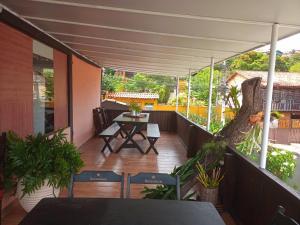 a balcony with a table and chairs and a tree at GO Hotelaria in Búzios
