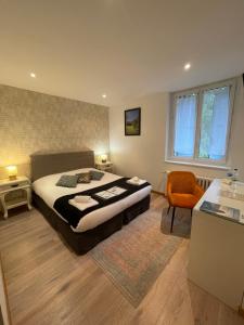 um quarto com uma cama king-size e uma cadeira em Domaine Du Moulin Vallée Heureuse em Poligny