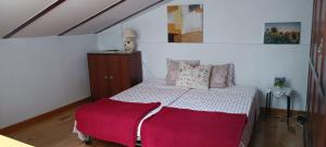 a bedroom with a bed with a red blanket on it at Acogedora casa de pueblo con piscina in Fuenteheridos