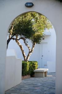 an archway with a bench and a tree in front of a building at Blue Beach Villas Apartments in Stavros