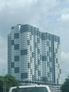 ein hohes Gebäude mit einem davor geparkt in der Unterkunft MyHOMESTAY 2 @ Vista Bangi in Kajang