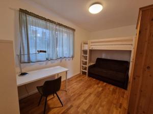 Schlafzimmer mit einem Schreibtisch und einem Etagenbett in der Unterkunft Gemütliche Premium Ferienwohnung mit Terrasse nähe S-Bahn in Burgthann