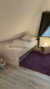 a bed in a room with a purple rug at Gästehaus Bönebüttel-nahe Neumünster Netflix in Bönebüttel