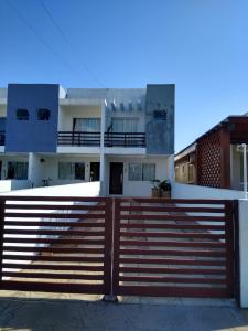 una casa con una valla de madera delante de ella en Solar Bella Torres, en Passo de Torres