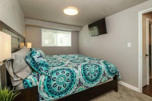 a bedroom with a bed with a blue and white comforter at HOLLY FIRST FLOOR 2 King Beds in Kansas City