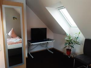 Habitación con escritorio, TV y ventana. en Gästezimmer im "Haus im Wellenfeld", en Peine