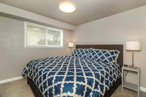 Un dormitorio con una cama azul y blanca y una ventana en HOLLY SECOND FLOOR 2 King Beds en Kansas City