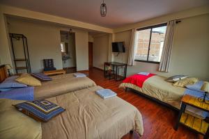拉巴斯的住宿－ISKAY BOUTIQUE HOSTEL，一间设有两张床和电视的房间
