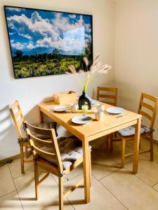 a wooden dining room table with chairs and a painting on the wall at Zwischen Wolfsburg, Tankumsee und Ilkerbruch - Apartment im Boldecker Land in Osloß
