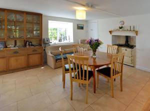 a kitchen and dining room with a table and chairs at Cronk Darragh Cottage in Castletown