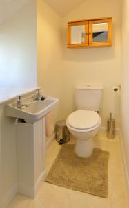 a bathroom with a toilet and a sink at Cronk Darragh Cottage in Castletown