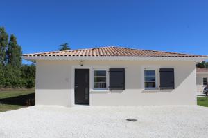 a white house with black shutters on it at Gîte Lou, Gîte famille et bien être avec jacuzzi in Fontenay-le-Comte