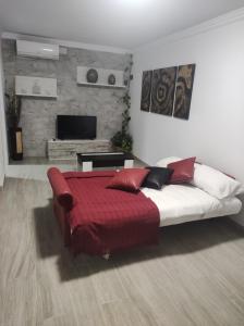 a bedroom with a large bed with a red blanket at Apartamento Daniela 1 in Ronda