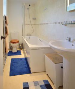 a bathroom with a tub and a sink and a toilet at Cronk Darragh Cottage in Castletown