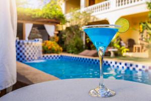 ein blaues Getränk auf einem Tisch neben einem Pool in der Unterkunft Hotel Villa Terra Viva in Jericoacoara