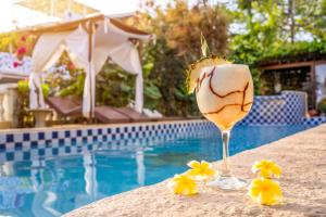 um copo de vinho sentado ao lado de uma piscina em Hotel Villa Terra Viva em Jericoacoara