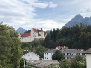 uma cidade com um grande edifício numa montanha em Family Apartment Bavaria em Füssen