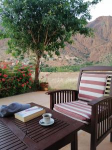 a wooden table with a book and a cup of coffee on a table at Auberge Tilila in Tafraout