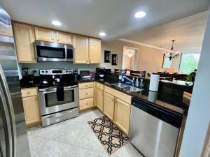 a kitchen with stainless steel appliances and wooden cabinets at Seaside Treasure in Biloxi