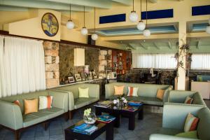a waiting room with couches and tables and a clock at Blue Beach Villas Apartments in Stavros