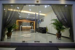 a lobby with two potted plants in a building at Hotel Setia in Kluang