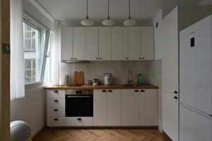 a kitchen with white cabinets and a window at Hidden Gem in Belgrade