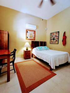 - une chambre avec un lit, une table et un bureau dans l'établissement Casa Quetzal Hotel, à Valladolid