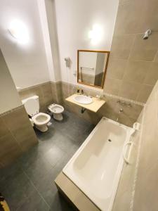 a bathroom with a tub and a toilet and a sink at Hotel Monterrey in Termas de Río Hondo +4 photos
