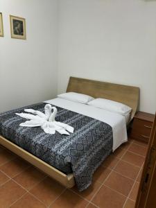 Un dormitorio con una cama con una flor blanca. en Agrimar 2 en Rignano Flaminio