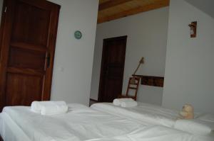 two beds in a room with white sheets and towels at Cisna Chata in Cisna