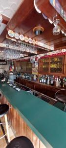 a bar with a green counter in a restaurant at Black Bear Bikers Pub-Hotel in Kempfeld