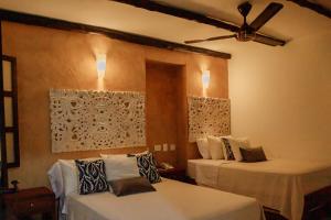 a bedroom with two beds with white sheets at Terra Inn Hotel Boutique in Guaduas