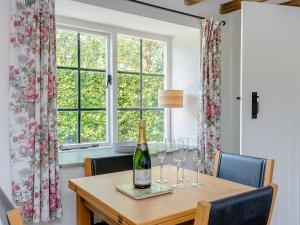 a table with glasses and a bottle of wine on it at Eton Cottage in Farnham