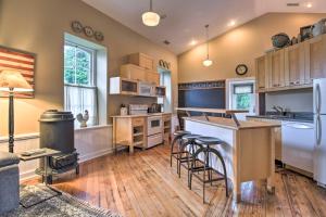 a kitchen with a counter and stools in it at Cozy Wrightsville Cottage with Private Hot Tub! in Wrightsville
