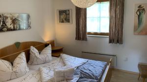 a bedroom with a bed with white pillows and a window at Apartment Famli Relax Kärnten in Feistritz im Rosental