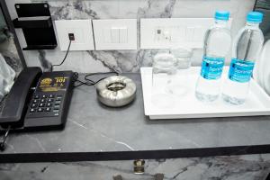 un bancone con due bottiglie d'acqua e un telefono di JSM Residency a Chennai