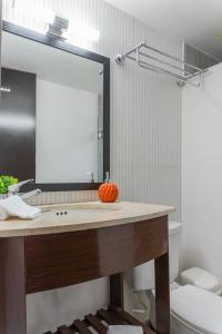 La salle de bains est pourvue d'un lavabo et d'un miroir. dans l'établissement Pako Stays - Luxurious & Spacious 2 Bedroom Apartments Close to the Beach, Free Wi-Fi, Ideal Location in Downtown Cancun Centro, à Cancún