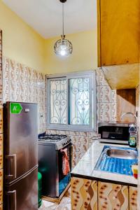 a kitchen with a stainless steel refrigerator and a sink at Beautiful- 1 Bedroom Apartment - Parking on site in Douala