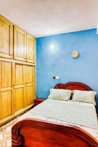 a bedroom with a bed with a blue wall at Beautiful- 1 Bedroom Apartment - Parking on site in Douala