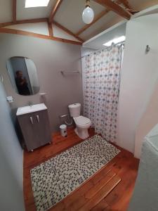 a bathroom with a toilet and a sink and a mirror at El Rodeo Glamping in Toca