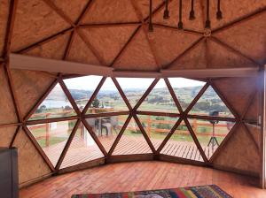 Großes Zimmer mit einem großen Fenster in einem Gebäude in der Unterkunft El Rodeo Glamping in Toca