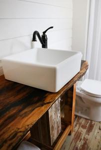 a white sink on a wooden counter in a bathroom at Sweetwater Branch Inn in Gainesville