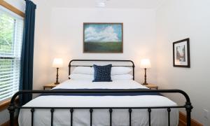 um quarto com uma cama e 2 candeeiros em Sweetwater Branch Inn em Gainesville