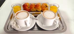 two cups of coffee and pastries on a tray at Hotel Venus in Buenos Aires