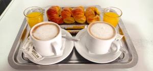 dos tazas de café y pastas en una bandeja en Hotel Venus, en Buenos Aires