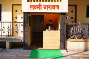 a man sitting at a counter in a building at Hotel laxminarayan in Shirdi