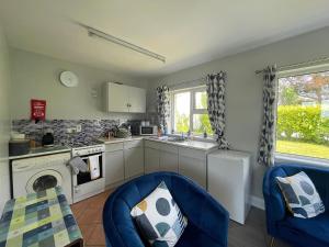 a kitchen with blue chairs and a stove top oven at Fernfield Cottage in Donegal
