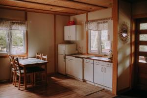 a kitchen with a table and a white refrigerator at Biała Dom z widokiem in Biala