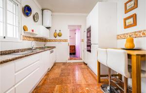 a kitchen with white cabinets and a wooden table at Lovely Home In Valencina De La Concep in Valencina de la Concepción