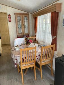 uma sala de jantar com uma mesa e duas cadeiras em Mobilhome em Noyelles-sur-Mer